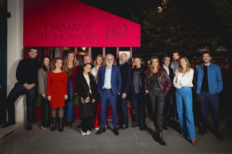 Photo de groupe des invités du dîner de fin de saison d’Espèces d’espaces, debout devant la façade du restaurant Daimant St-Honoré, à Paris, de nuit.